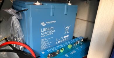 Batería de litio Victron de 12.8V y 330Ah instalada con conexiones a sistemas eléctricos en una embarcación, resaltando seguridad y optimización del espacio.