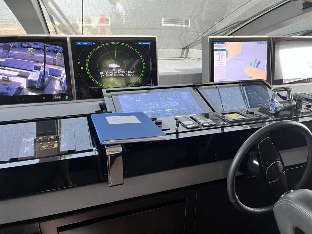 Vista de una cabina de navegación moderna con múltiples pantallas que muestran datos del piloto automático, radar y mapas electrónicos.