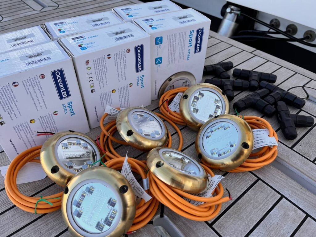 Conjunto de luces subacuáticas OceanLED modelo Sport S3165 en preparación para instalación, con cables y conectores visibles.