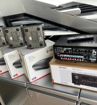 Vista de un sistema de audio inalámbrico compuesto por múltiples altavoces y un receptor Denon destinado a uso en embarcaciones.