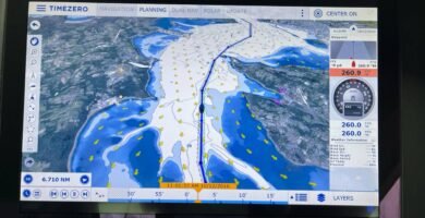 Pantalla de un sistema de navegación TimeZero mostrando un mapa con rutas, información meteorológica y datos de navegación.. TimeZero, .