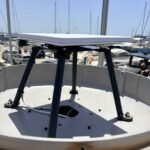 Starlink Standard flat antenna mounted on a custom marine bracket above a yacht deck in a marina