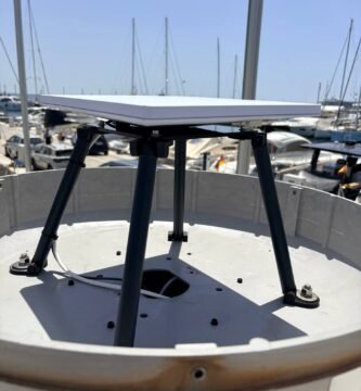 Starlink Standard flat antenna mounted on a custom marine bracket above a yacht deck in a marina